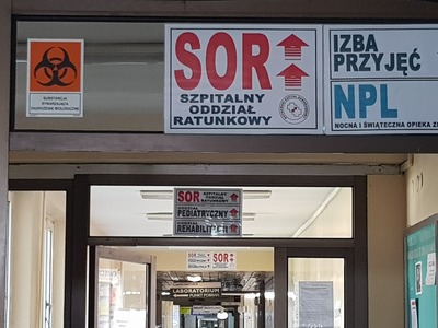 Na parterze rozmieszczono tablice informacyjne z dużym czerwonym napisem SOR i strzałką kierunkową.